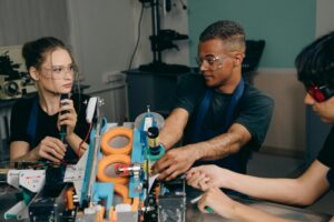 Three engineers collaborate on industrial machinery, emphasizing teamwork and technology in a manufacturing setting.